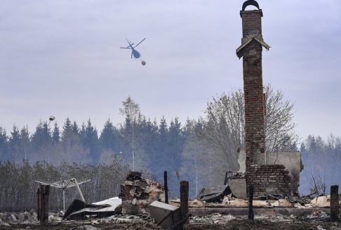 Johan Nilsson/TT En helikopter vattenbombar skogen bakom den nerbrunna hästgården vid Tulatorp utanför skånska Hästveda på onsdagen. Johan Nilsson/TT En helikopter vattenbombar skogen bakom den nerbrunna hästgården vid Tulatorp utanför skånska Hästveda på onsdagen.