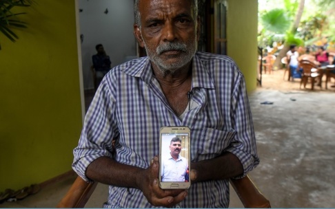 LAKRUWAN WANNIARACHCHI Velusami Raju håller upp en bild på sin telefon av sin son Ramesh Raju som dog i ett av attentaten. LAKRUWAN WANNIARACHCHI Velusami Raju håller upp en bild på sin telefon av sin son Ramesh Raju som dog i ett av attentaten.