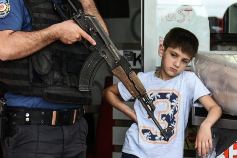 En pojke tittar bredvid en polis som håller sin Kalashnikov under en demonstration i solidaritet med kurdiska fångar i Diyarbakir den 24 maj 2019. Foto av ILYAS AKENGIN / AFP En pojke tittar bredvid en polis som håller sin Kalashnikov under en demonstration i solidaritet med kurdiska fångar i Diyarbakir den 24 maj 2019. Foto av ILYAS AKENGIN / AFP