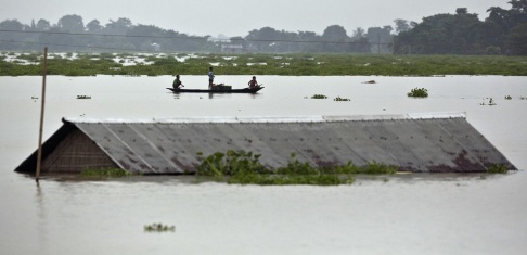 Anupam Nath Bybor ror förbi ett hus i östra delstaten Assam i Indien, som drabbats hårt av regnen. Anupam Nath Bybor ror förbi ett hus i östra delstaten Assam i Indien, som drabbats hårt av regnen.