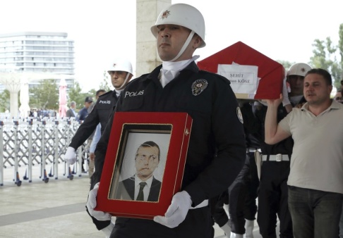 Burhan Ozbilici/AP/TT En polis bär en bild av den turkiske diplomat som dödades i Erbil inför mannens begravning i Ankara. Burhan Ozbilici/AP/TT En polis bär en bild av den turkiske diplomat som dödades i Erbil inför mannens begravning i Ankara.