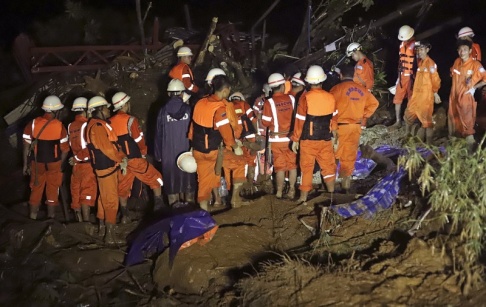Räddningsarbetare jobbar efter ett jordskred i östra Myanmar. Räddningsarbetare jobbar efter ett jordskred i östra Myanmar.