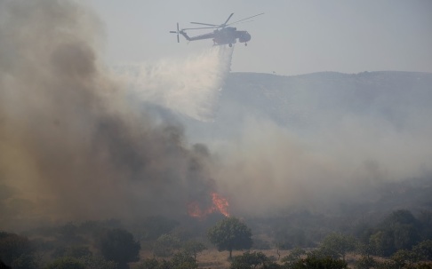Thanassis Stavrakis/AP/TT En helikopter vattenbombar en brand nära staden Marathon, nordost om Greklands huvudstad Aten på lördagen. Thanassis Stavrakis/AP/TT En helikopter vattenbombar en brand nära staden Marathon, nordost om Greklands huvudstad Aten på lördagen.