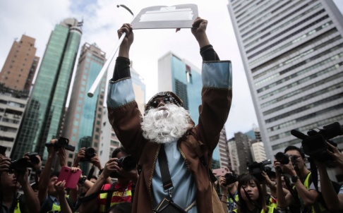 Jae C Hong/AP/TT En demonstrant utklädd till Moses håller upp en stentavla vid en protest i Hongkong. Jae C Hong/AP/TT En demonstrant utklädd till Moses håller upp en stentavla vid en protest i Hongkong.
