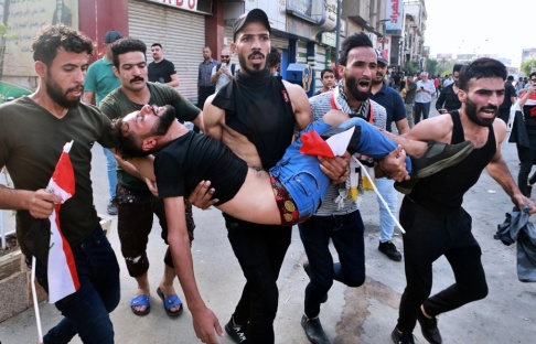 Khalid Mohammed/AP/TT Hundratals människor i Bagdad och i södra Irak protesterade mot bland annat korruption under tisdagen. Här bärs en skadad demonstrant bort. Khalid Mohammed/AP/TT Hundratals människor i Bagdad och i södra Irak protesterade mot bland annat korruption under tisdagen. Här bärs en skadad demonstrant bort.