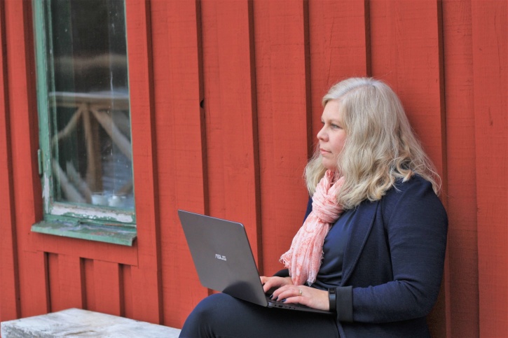 Bilden föreställer Charlotta Hurtig som sitter med en laptop i knät utanför ett falurött hus. Charlotta är digital kommunikation på CH Digitalbyrå. Bilden föreställer Charlotta Hurtig som sitter med en laptop i knät utanför ett falurött hus. Charlotta är digital kommunikation på CH Digitalbyrå.