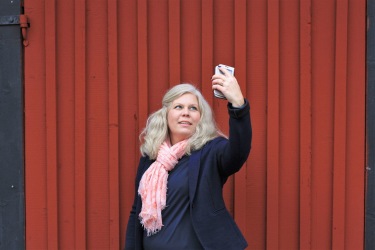 Bilden föreställer Charlotta Hurtig, digital kommunikatör på CH Digitalbyrå, som tar en selfie mot en faluröd vägg. Bilden föreställer Charlotta Hurtig, digital kommunikatör på CH Digitalbyrå, som tar en selfie mot en faluröd vägg.