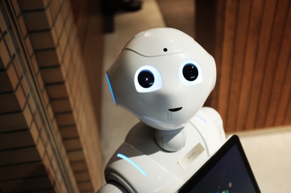 Bild på en gullig, vit robot som tittar in i kameran med stora, snälla ögon.