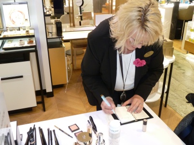 Fyll i dina makeupfärger i färgpasset. (På bilden syns Lancomes expert på NK.)