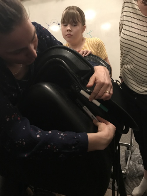 Pia visar vinkel mellan bomben och häst för att förklara hur man vet om en sadel passar Pia visar vinkel mellan bomben och häst för att förklara hur man vet om en sadel passar