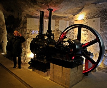 Eva Larsson, Länsmuseet, guidade oss i Sickla. Här framför en av Atlas första kompressorer, som räddades från ödet att skrotas. Foto Lars Höglund. Eva Larsson, Länsmuseet, guidade oss i Sickla. Här framför en av Atlas första kompressorer, som räddades från ödet att skrotas. Foto Lars Höglund.