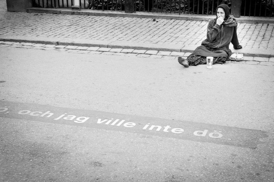 Drottningatan i Stockholm. August Strindbergs rader ses infasade i asfalten. Kvinnan är säkert ovetandes om textens träffsäkerhet. Copyright Thommy Jakobsson / klickbar bild