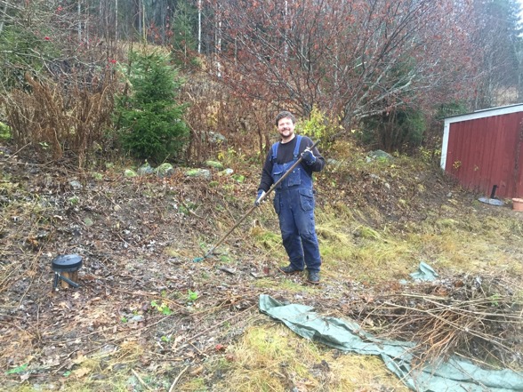 Uffe in action rensar sly och gräs i slänten framför huset. I bakgrunden ser man förrådet Uffe in action rensar sly och gräs i slänten framför huset. I bakgrunden ser man förrådet