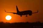 A Boeing 737-800 about to land at sunset