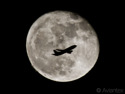 A Boeing 737 passes the full moon