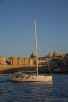 Sailboat infront of the walls around Valletta, Malta