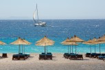 Dhërmi beach with aligned sun beds and parasols