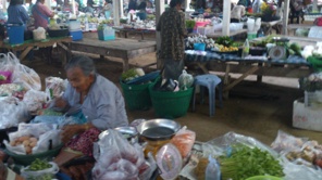 Gammal dam säljer grönsaker