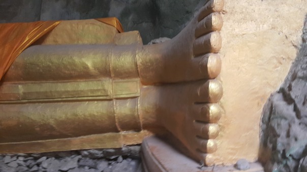 Líggande Buddhas fötter i guld