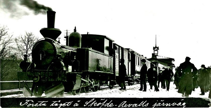 1903-03-31 avgick det första allmänna tåget från Skövde med loket "Sköfde" framför kombinerad gods- och postvagn och passagerarvagnar. Svag ostlig vind. Fortfarande vintrigt. (Skövde Stadsmuseum)