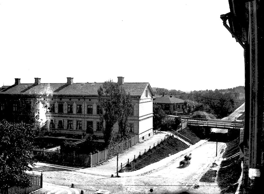 Undergången före SAJ-bron med "Gejierska huset" (Järnvägshotell 1913), Mörketrappan, Vattenkurens Societetssalong, Öm-vägen och Jungfrukällan i slänten t h i bild. (Skövde Stadsmuseum)