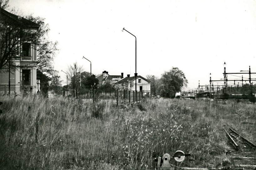 1965 var spåret delvis upprivet. Växel för bangårdsspår ännu kvar. Skolgatan 2 ser ödsligt ut. Nytt posthus har tagit det stora Grönvallska/Pettersonska huset längst bort i bild. (Skövde Stadsmuseum)