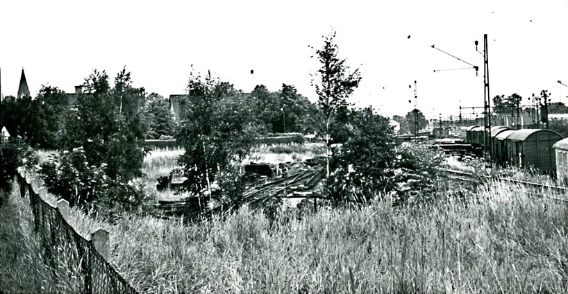 1965. Nästan på järnvägsövergången vid Vasaplan. SAJ's bangård i spillror inför nya tider. SAJ's spår mot Axvall nu övertaget av Gullhögen och utan tre-skenan. (Skövde Stadsmuseum)